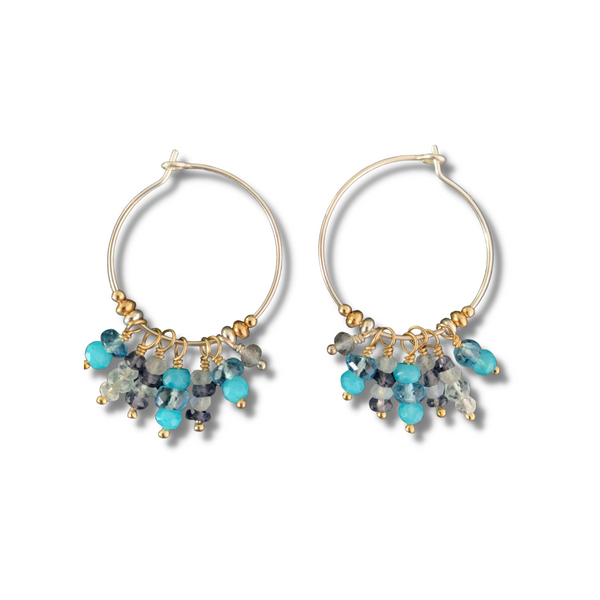 These gleaming hoops are packed with colorful gemstones and are lightweight enough to wear all day. Aquamarine, aqua chalcedony, blue topaz, rainbow moonstone, labradorite, and iolite faceted gemstones on sterling silver hoops. 1" sterling silver hoops with 1/2" dangles.